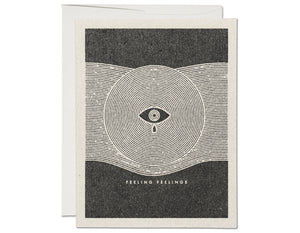 BLACK AND WHITE DESIGN OF CIRCLE AND EYE WITH TEAR. TEXT READS FEELING FEELINGS 