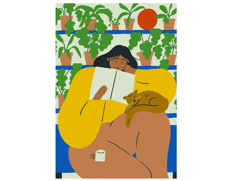 woman reading book with cat and tea on her lap and a wall of house plants in the background