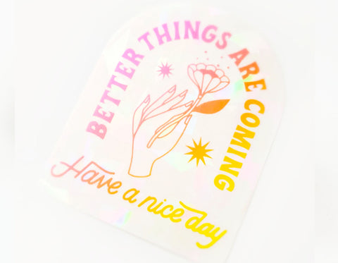 suncatcher sticker text reads better things are coming has hand holding flower says have a nice day at the bottom